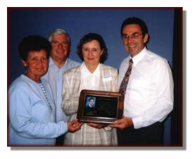 Rod and Paulette Moffitt presenting Sears Brockville staff with a plaque